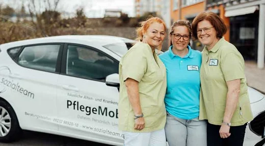 PflegeMobil Regensburg Pflegerinnen vor PflegeMobil Auto, lächeln, ambulanter Pflegedienst
